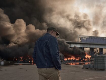 KYIV, UKRAINE - AUGUST 29: A man looks on as smoke rises from a fire at a large warehouse