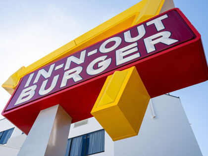 Low angle view of In-N-Out Burger sign in front of a white building on a clear day, San Fr