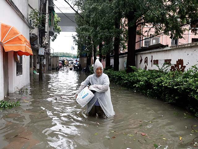 Residents wade through waterlogged areas on August 10, 2026 in Shanghai, China. Typhoon Do