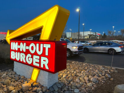 Customers pass by the illuminated sign outside an In-N-Out Burger restaurant Sunday, Dec.c