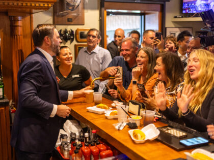 US Vice President JD Vance hands out a beer from behind the bar during a stop at Price Hil