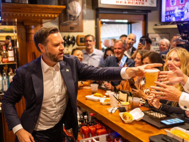 US Vice President JD Vance hands out a beer from behind the bar during a stop at Price Hil