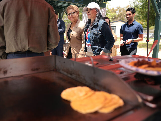 L.A. Mayor Karen Bass, center, walks with Avance Democratic Club president Nilza Serrano,