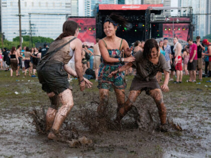 CHICAGO, IL - AUGUST 07: Festival-goers play in the mud during Lollapalooza Festival 2011