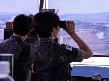 A Republic of Korea air force interpreting officer uses binoculars to observe the flight l