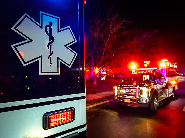 Close up emergency ambulance truck illuminated at night accident response