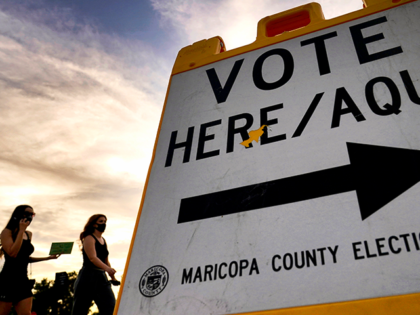 FILE - Voters deliver their ballot to a polling station in Tempe, Ariz., on Nov. 3, 2020.