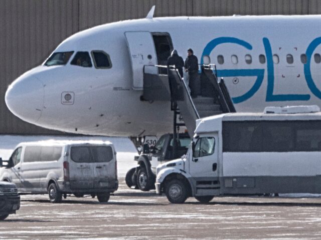Shackled deportees board a GlobalX plane at the Minneapolis-Saint Paul International Airpo