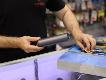 Ian Brabender helps a customer buying a gun suppressor at WEX Gunworks on March 24, 2021 i