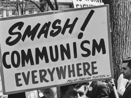 A representative of the Polish Freedom Fighters Inc holds a placard reading 'Smash Co
