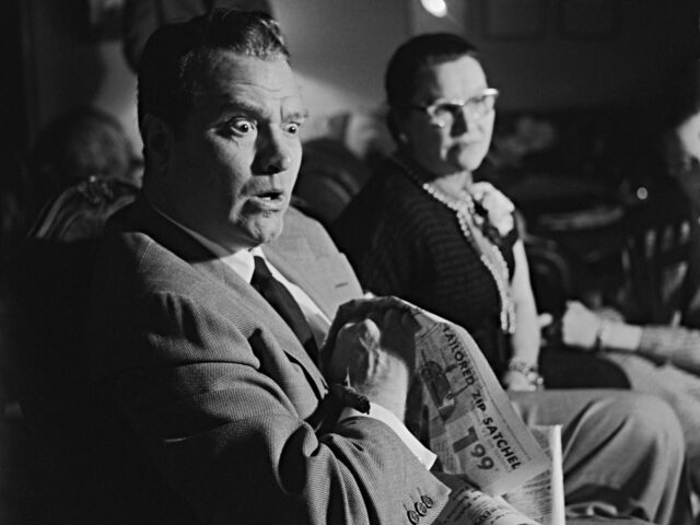 television surprise Red Skelton sits with a look of amazement on his face as he watches television with his mo