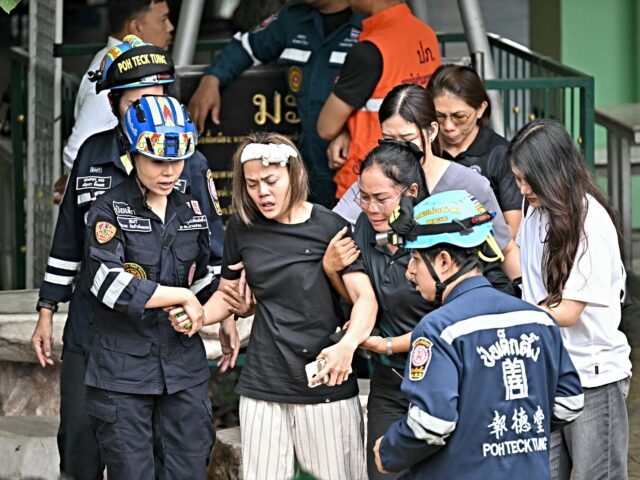 thailand shooting TOPSHOT - The wife (C) of a teacher who was killed in a school shooting is led to an ambul