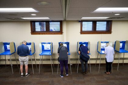 Voters fill out their ballots in a polling place at Merriam Park Library on August 11, 202