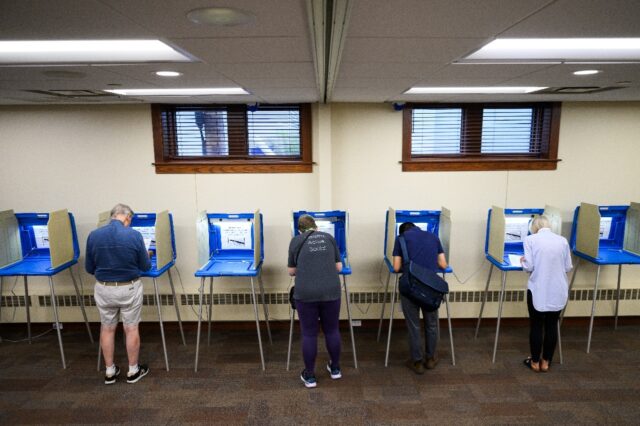 Voters fill out their ballots in a polling place at Merriam Park Library on August 11, 202