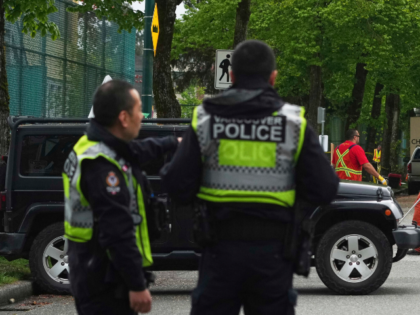 Vancouver Police watch as city workers begin to clear the scene where a driver killed mult