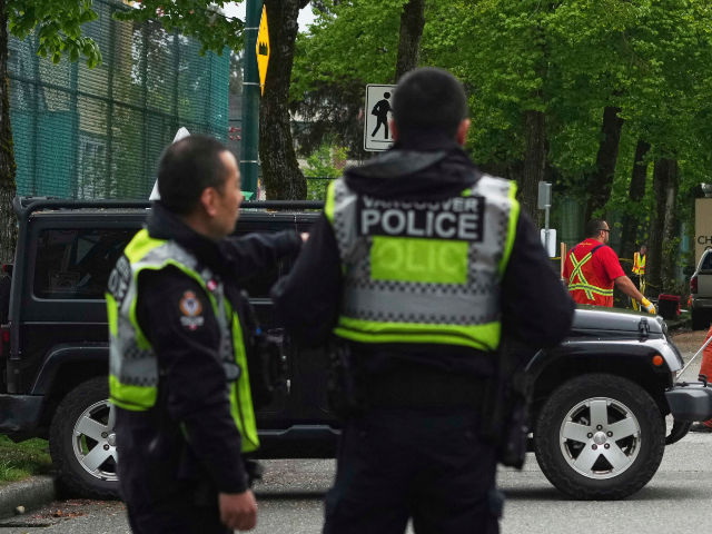Vancouver Police watch as city workers begin to clear the scene where a driver killed mult