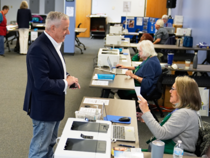Republican U.S. Senate candidate Michael Whatley, center, checks in at an early voting sit