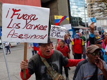 Title: Venezuela US Trump Oil Image ID: 26241640639942 Article: A man holds a sign with a