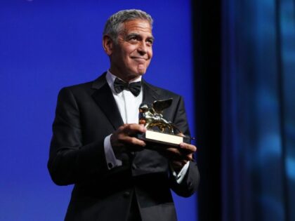 George Clooney poses with the golden lion for lifetime achievement during the opening cere