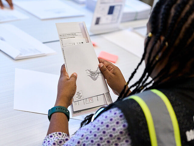 AP26246568670102 Wake County Board of Elections employees prepare absentee ballots to be mailed on Thursday