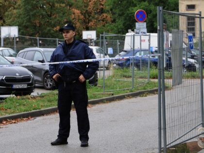 A police officer stands near the high school where a student stabbed and injured another s