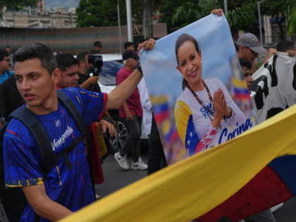 Supporters of opposition leader Maria Corina Machado hold a poster of her during a protest