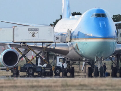 Catering trucks are parked at Air Force One on the tarmac as the motorcade carrying U.S. P