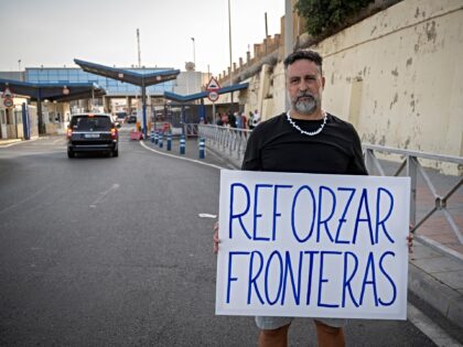 CEUTA, SPAIN - AUGUST 31: A person stands holding a placard on the border with Morocco on