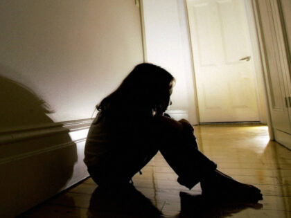 A child sits in the hallway of a house, 30 August 2005. THE AGE Picture by JOHN DONEGAN (P