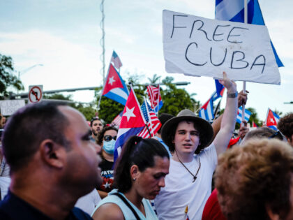 A man holds a "Free Cuba" sign during a Freedom Rally showing support for Cubans