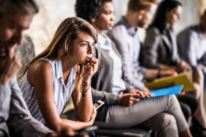 Worried businesswoman waiting for job interview with other candidates.