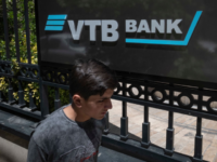 An Iranian man walks past a sign of the Russian VTB Bank, hanged on the entrance to a building where the bank's representative office is located in, in northwestern Tehran, May 18, 2023. VTB Bank, which is the Russia's second largest bank, has open its representative office in Iran. (Photo by Morteza Nikoubazl/NurPhoto via Getty Images)