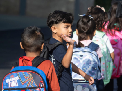ANAHEIM, CA - August 08: A student waves good-bye as he heads to his classroom on the firs
