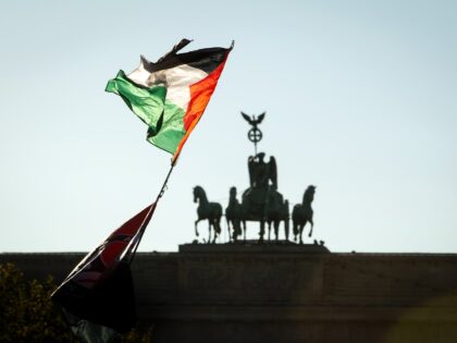 BERLIN, GERMANY - SEPTEMBER 27: A Palestian flag is carried by a protestor while approachi