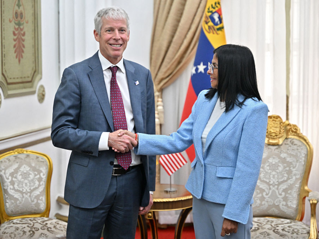 US Secretary of Energy Chris Wright (L) shakes hands with Venezuela's acting president Del