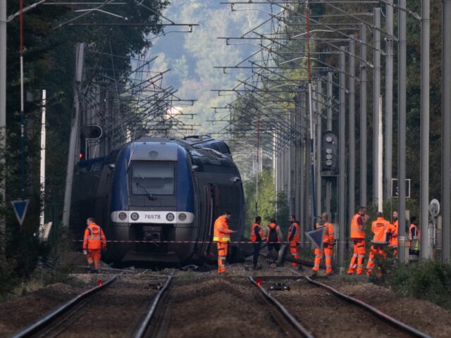 SNCF agents walk around a crashed train in Cleon, northwestern France, on September 12, 20