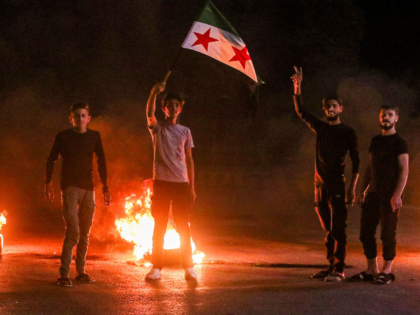 Demonstrators block a road with flaming tires while protesting hikes to fuel prices in al-