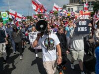 PORTSMOUTH, ENGLAND - SEPTEMBER 12: Demonstrators participate in an anti-migrant protest marching to Guildhall square on September 12, 2026 in Portsmouth, England. A volunteer RNLI crew rescued approximately 140 migrants from a "mega dinghy" crossing the English Channel last Sunday night, triggering intense far-right protests and road blockades in Eastney, Portsmouth. Stand Up To Racism are staging a counter protest to today's far right march by the self-styled South Coast Patriots. (Photo by Guy Smallman/Getty Images)