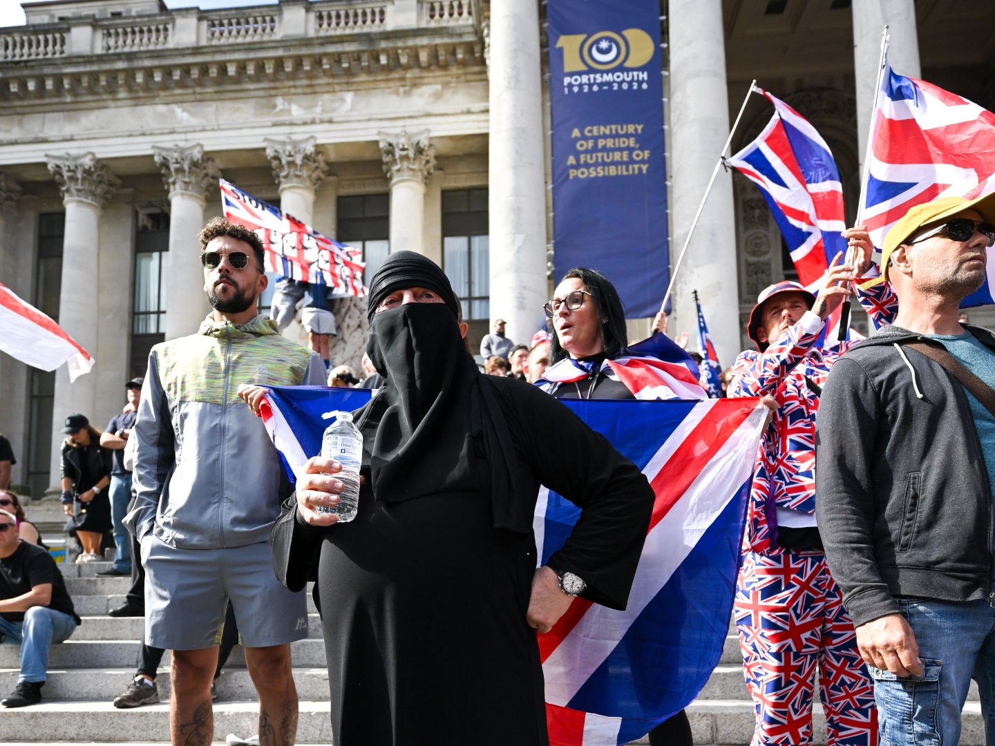 PORTSMOUTH, ENGLAND - SEPTEMBER 12: An anti-migrant protester wears a burkha during an anti-migrant march through the city to Guildhall, on September 12, 2026 in Portsmouth, England. A volunteer RNLI crew rescued approximately 140 migrants from a