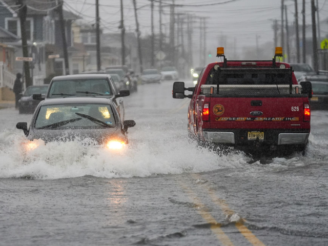 GettyImages-2296644276 POINT PLEASANT, NEW JERSEY - SEPTEMBER 26: Cars drive through a flooded road during a nor'