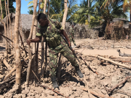 Mozambican Army soldiers bring down a structure torched by attackers to be rebuilt as shel