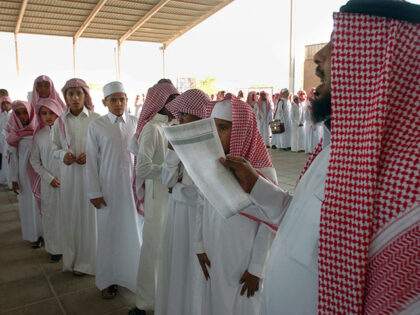 Saudi boys stand in line as a teacher takes the attendance on their first day back to scho