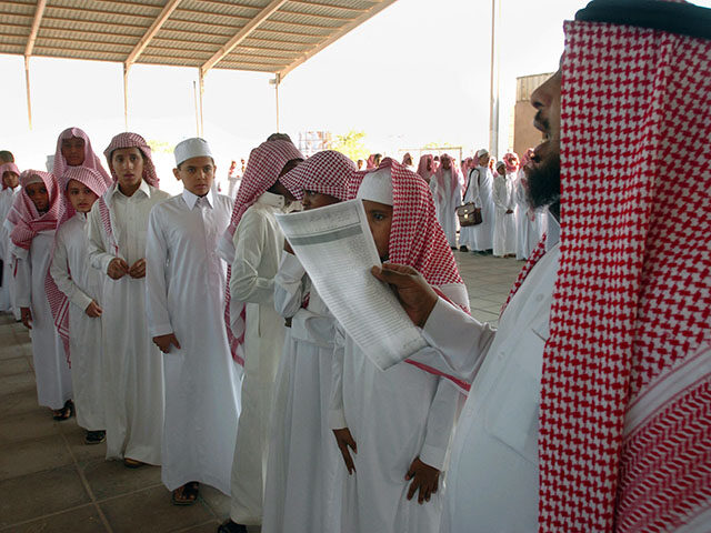 GettyImages1244104695 Saudi boys stand in line as a teacher takes the attendance on their first day back to scho