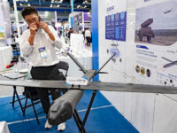 An exhibitor makes a phone call next to the EA040 loitering munition drone showcased at the defense tech zone during EV Trend Korea 2026 held at COEX in Gangnam-gu, Seoul, South Korea, on August 25, 2026. (Photo by Chris Jung/NurPhoto via Getty Images)