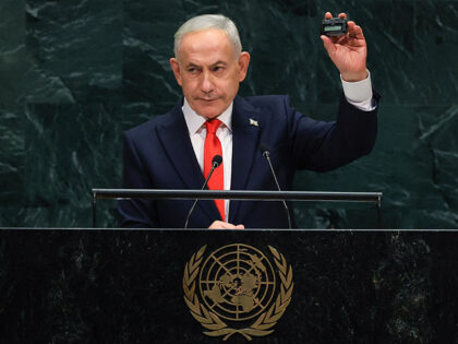Israel's Prime Minister Benjamin Netanyahu holds up a pager as he speaks during the 81st U