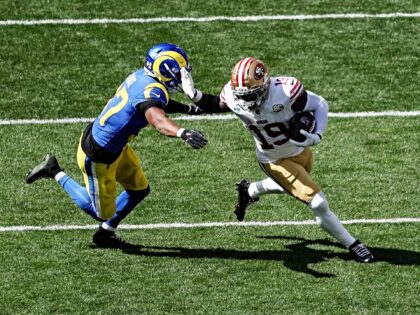 San Francisco 49ers' wide receiver #19 Deebo Samuel Sr. (R) fends off Los Angeles Rams' sa