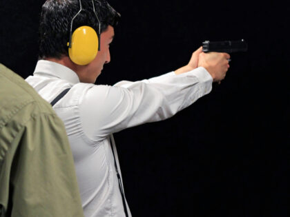 Man in long-sleeved white shirt practices shooting.