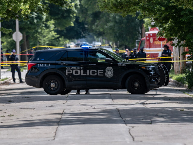 Milwaukee police Officers patrol the crime scene where a man was shot and killed by police near King Park o
