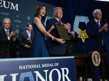 U.S. President Donald Trump is given a "Champion of Honor" plaque by Charlotte J