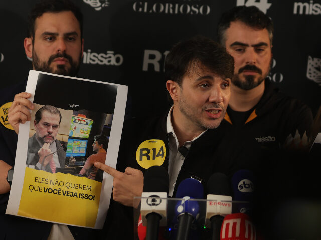 Renan Santos Renan Santos holds a poster featuring an image of Supreme Court Justice Dias Toffoli durin